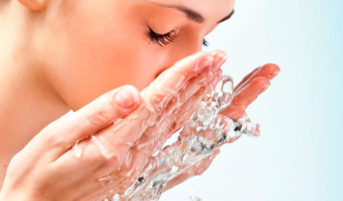 момиче измива лицето си с вода