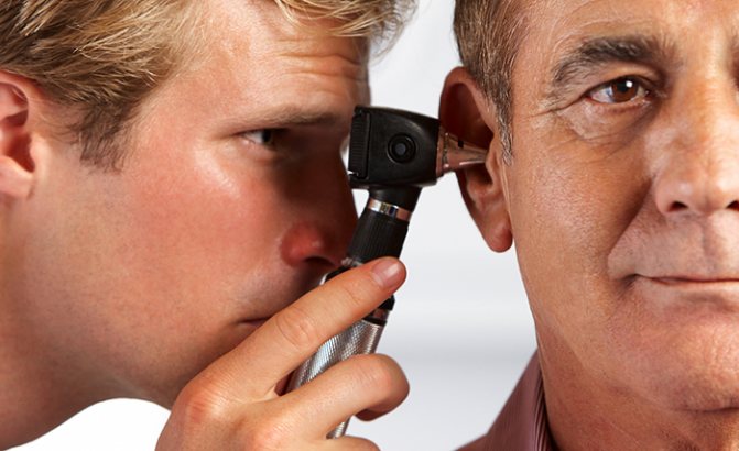 The doctor examines the ear