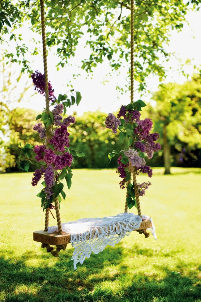 Gör-det-själv gunga dekorerad med färska blommor kommer att ge en känsla av romantik i din trädgård