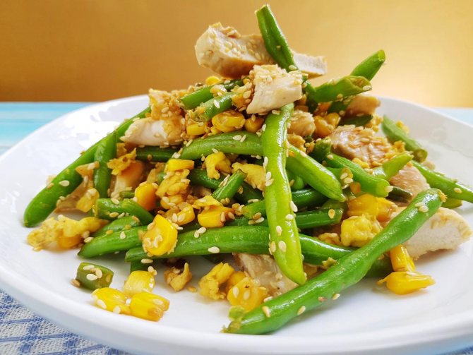 green beans with meat and corn, sprinkled with sesame seeds