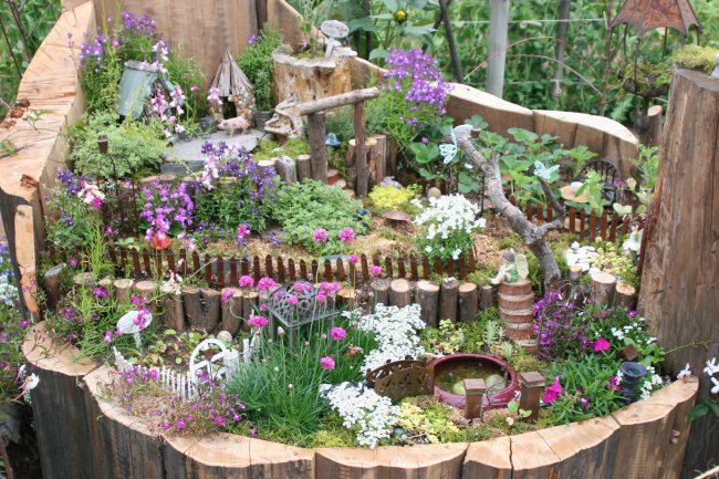 Magnifik mini-trädgård i en konstgjord stubbe